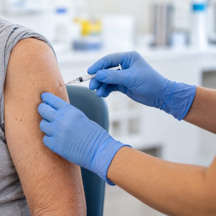 DI sukurta nuotraukų tipo iliustracija: skiepijimo į žastą situacija; tai nėra tikras pacientas ar konkretus vakcinos preparatas.